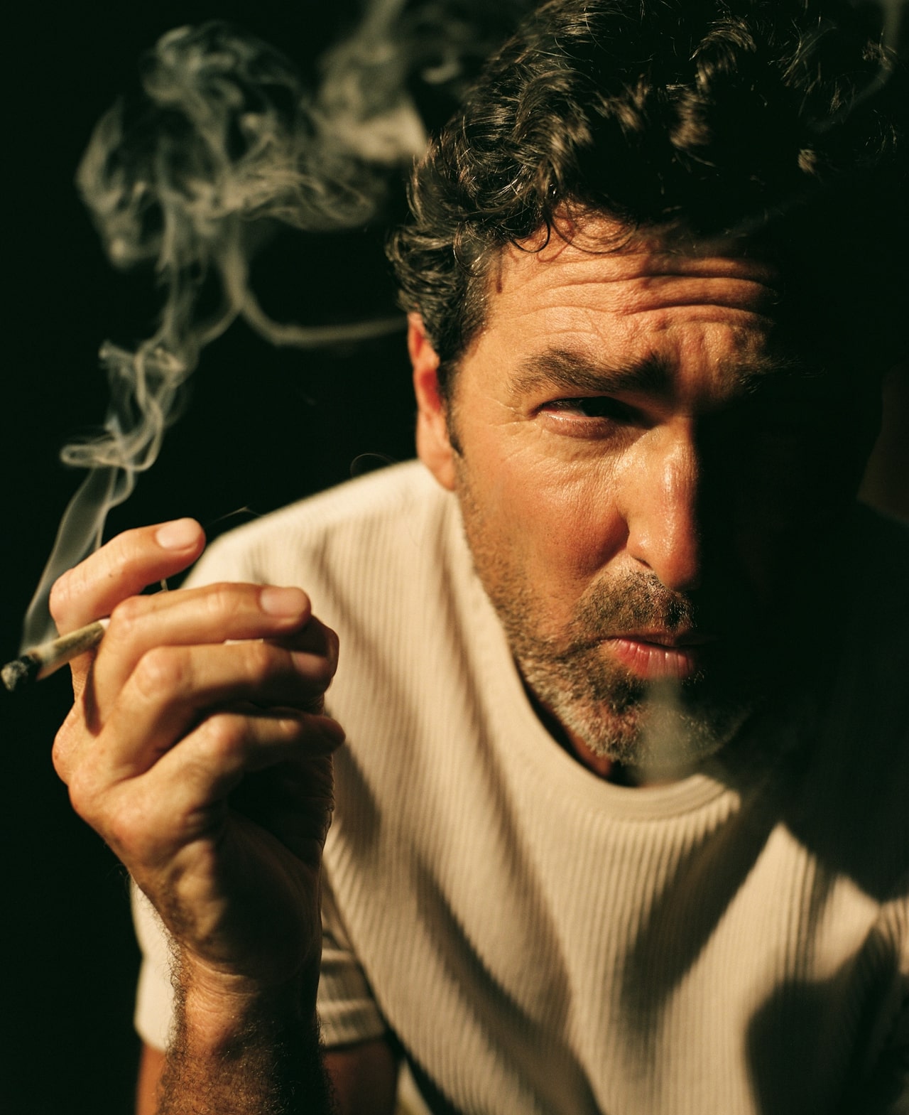 man smoking joint up close with smoke