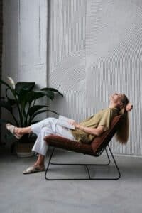 person relaxing on chair with book
