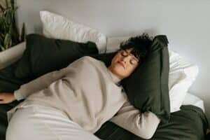 lady laying down on bed with pillows