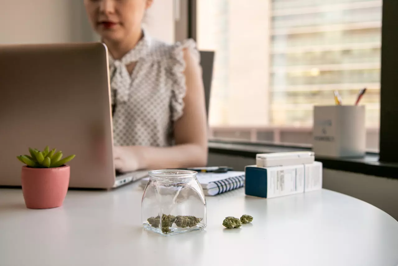 woman at computer with weed on the table